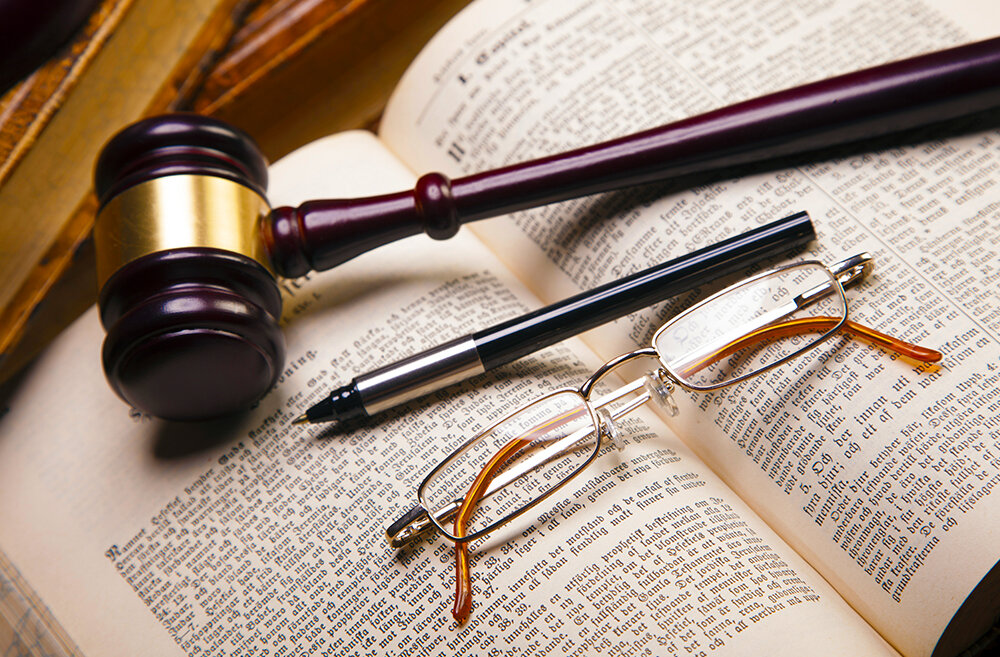 Richterhammer und Brille auf Buchseite Arbeitsrecht